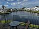 Relaxing balcony overlooking a lake with patio furniture at 2520 Woodgate Blvd # 202, Orlando, FL 32822