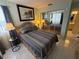 Second bedroom with striped bedding and mirrored closet at 2520 Woodgate Blvd # 202, Orlando, FL 32822