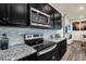 Modern kitchen with black cabinets, granite countertops and stainless steel appliances at 3032 Mahalo Dr, Davenport, FL 33897