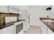 White appliances and mosaic backsplash in this galley-style kitchen at 6214 Stevenson Dr # 303, Orlando, FL 32835