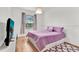 Bedroom with wood floors, large window, and lavender bedding at 6214 Stevenson Dr # 303, Orlando, FL 32835