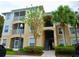 Two-story condo building with balconies and palm trees at 6214 Stevenson Dr # 303, Orlando, FL 32835