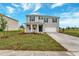 Two-story house with gray siding, blue shutters, and a white garage door at 1209 Limbali St, Mount Dora, FL 32757