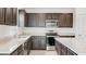Modern kitchen with dark brown cabinets and granite countertops at 1209 Limbali St, Mount Dora, FL 32757