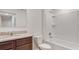 Bathroom with granite countertop, dark brown vanity, and a bathtub at 1209 Limbali St, Mount Dora, FL 32757