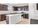Modern kitchen featuring dark brown cabinets, granite countertops, and an island at 1209 Limbali St, Mount Dora, FL 32757