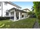 Covered patio, grassy lawn, and privacy hedges at 1429 Chapman Cir, Winter Park, FL 32789