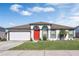Single-story home with a white exterior, red door, and attached garage at 3618 Wellington Ln, Bartow, FL 33830