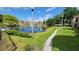 Serene community pond with walkway, fountain, and lush landscaping at 4400 Thornbriar Ln # 201, Orlando, FL 32822