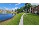 Walkway next to pond offering scenic views of community at 4400 Thornbriar Ln # 201, Orlando, FL 32822