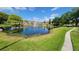 Community pond with fountain, landscaping, and surrounding buildings at 4400 Thornbriar Ln # 201, Orlando, FL 32822