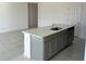Kitchen island with sink, dishwasher, and gray cabinets at 6817 Serpent Hawk Lane St, Howey In The Hills, FL 34737