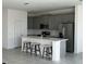 Modern kitchen featuring gray cabinets, an island, and stainless steel appliances at 6817 Serpent Hawk Lane St, Howey In The Hills, FL 34737