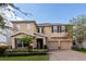 Two-story house with tan siding, three-car garage, and landscaped yard at 9036 Arbors Edge Trl, Windermere, FL 34786