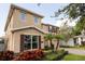 Two story house with tan siding, brown shutters, and lush landscaping at 9036 Arbors Edge Trl, Windermere, FL 34786