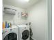 Convenient laundry room with washer, dryer, and storage shelves at 9036 Arbors Edge Trl, Windermere, FL 34786