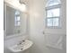Small bathroom with a pedestal sink, a mirror, and a window at 148 Brunello Dr, Davenport, FL 33897