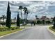 Community entrance with a fountain, palm trees, and a person walking a dog at 148 Brunello Dr, Davenport, FL 33897