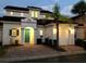 Charming home at dusk with a teal front door, a two-car garage, and landscaping at 148 Brunello Dr, Davenport, FL 33897