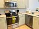 Stylish kitchen features stainless steel appliances, light green cabinets, and white countertops at 148 Brunello Dr, Davenport, FL 33897