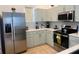 Clean and modern kitchen highlighting stainless steel appliances, light green cabinets, and white countertops at 148 Brunello Dr, Davenport, FL 33897