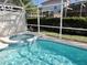 Clear pool and spa with lush landscaping, surrounded by a screened enclosure at 148 Brunello Dr, Davenport, FL 33897