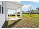 Covered patio overlooking a grassy backyard with a sloped terrain at 27472 Black Kite Ave, Howey In The Hills, FL 34737