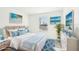 Virtually staged bedroom with a white bed, blue accents, and ocean artwork at 27472 Black Kite Ave, Howey In The Hills, FL 34737