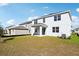Two-story house showcasing the back exterior with a grassy yard at 27472 Black Kite Ave, Howey In The Hills, FL 34737