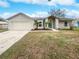 Tan one-story house with attached garage and landscaping at 5119 Timber Ridge Trl, Ocoee, FL 34761
