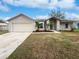 Tan one-story house with attached garage and landscaping at 5119 Timber Ridge Trl, Ocoee, FL 34761