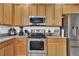Kitchen features stainless steel appliances and wood cabinets at 5364 Ragusa Loop, Saint Cloud, FL 34771