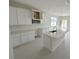 Modern kitchen with white cabinets, quartz countertops, and an island at 783 Pilea St, Apopka, FL 32703