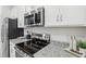 Modern kitchen with stainless steel appliances and granite countertops at 811 Pebble Crest Ln, Eagle Lake, FL 33839
