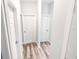 Clean hallway with wood-look floors and multiple doors at 8969 Sheppard Dr, Lake Wales, FL 33898