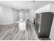 Open concept kitchen with island, stainless steel appliances, and wood-look floors at 8969 Sheppard Dr, Lake Wales, FL 33898