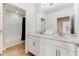 Double vanity bathroom with white cabinets and a large mirror at 9849 Lost Creek Dr, Winter Garden, FL 34787