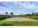 Outdoor sand volleyball court with net and lush green surroundings at 9849 Lost Creek Dr, Winter Garden, FL 34787