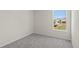 Bright bedroom with grey carpet and large window at 141 Holly Village Dr, Davenport, FL 33837