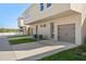 Tan townhouses with attached garages and landscaping at 141 Holly Village Dr, Davenport, FL 33837