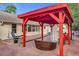 Red pergola-covered patio with brick pavers and outdoor seating at 1725 Singing Palm Dr, Apopka, FL 32712