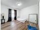 Simple bedroom with a bed, mirror and wood flooring at 1725 Singing Palm Dr, Apopka, FL 32712
