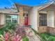 Inviting house exterior featuring a red door and well-manicured landscaping at 1725 Singing Palm Dr, Apopka, FL 32712