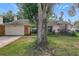 Charming single story home with a large tree in front at 1725 Singing Palm Dr, Apopka, FL 32712