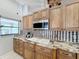 Kitchen with granite countertops, wood cabinets, and stainless steel appliances at 1725 Singing Palm Dr, Apopka, FL 32712