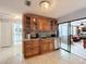 Kitchen with granite countertops, wood cabinets, and views into the sunroom at 1725 Singing Palm Dr, Apopka, FL 32712
