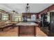 Kitchen with island, dark wood cabinets, and black appliances at 3250 Mountain Lake Cutoff Rd, Lake Wales, FL 33859