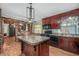 Open kitchen with island, dark wood cabinets, and black appliances at 3250 Mountain Lake Cutoff Rd, Lake Wales, FL 33859