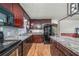 Kitchen with dark wood cabinets, granite countertops, and black appliances at 3250 Mountain Lake Cutoff Rd, Lake Wales, FL 33859
