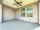 Covered patio with ceiling fan and screened windows, offering outdoor relaxation at 349 Alcove Dr, Groveland, FL 34736